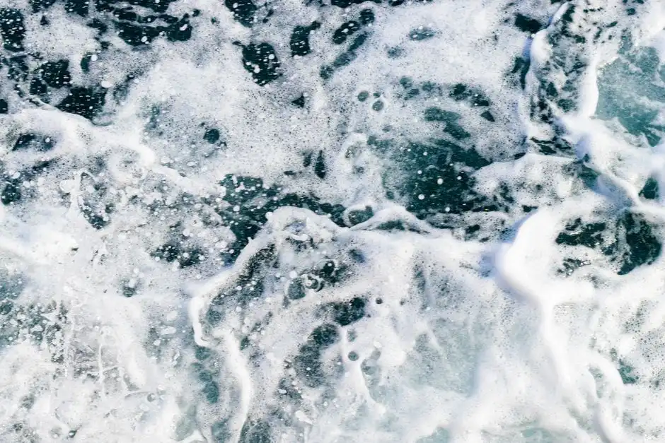 A close-up of powerful ocean waves creating mesmerizing white sea foam patterns.